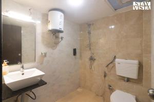 uma casa de banho com um WC, um lavatório e um chuveiro em StayVista's Villa Orchid - Pet-Friendly Villa with Lawn, Bonfire & Indoor-Outdoor Games em Ujaim