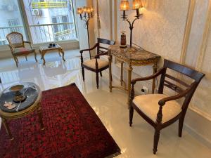 Sea View Luxury Apartment في الإسكندرية: غرفة معيشة مع كراسي وطاولة وسجادة