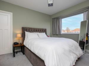 a bedroom with a large white bed and a window at Pass the Keys Family holiday home by the sea with free parking in Hove