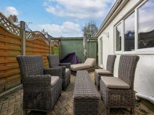 a group of wicker chairs and a couch on a patio at Pass the Keys Family holiday home by the sea with free parking in Hove