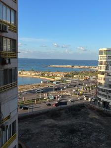 Sea View Luxury Apartment في الإسكندرية: اطلالة على موقف للسيارات بجانب المحيط