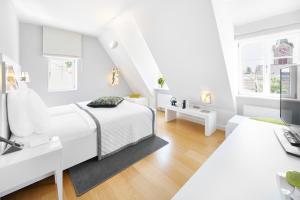 a white bedroom with a bed and a desk at Hotel Ketschauer Hof in Deidesheim