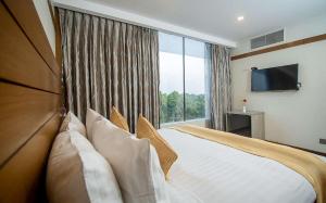 Hotel X Rajshahi في راجشاهي: غرفة نوم بسرير كبير مع نافذة كبيرة