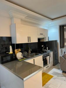 a kitchen with white cabinets and black appliances at Crush of the year in Dakar