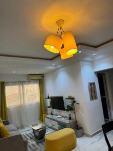 a living room with a yellow couch and a ceiling fan at Crush of the year in Dakar
