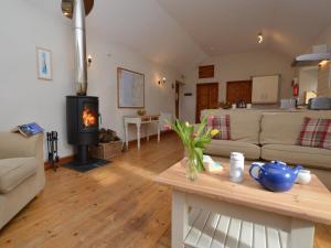 a living room with a couch and a stove at 2 Bed in Bude CORYB in Morwenstow