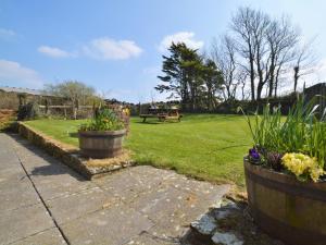 a garden with two pots of flowers and a park at 2 Bed in Bude CORYB in Morwenstow