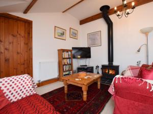 uma sala de estar com um sofá e um fogão a lenha em 2 Bed in Glastonbury THEOL em Stawell