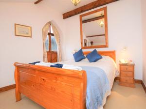 a bedroom with a wooden bed with a dresser and a mirror at 2 Bed in Glastonbury THEOL in Stawell