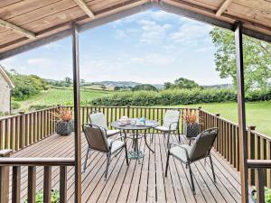 a patio with a table and chairs on a wooden deck at 1 Bed in Lyme Regis WHOUS in Axminster