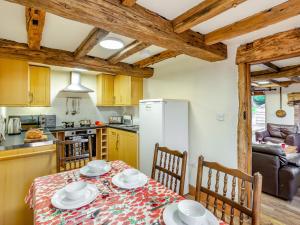 Highley的住宿－3 Bed in Bewdley THFIS，厨房配有桌椅和冰箱。