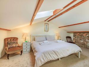a bedroom with a bed and a chair at 1 Bed in Sidmouth SWCOM in Sidbury