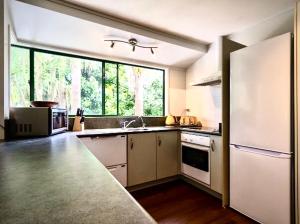 a kitchen with a sink and a large window at Hatea Treehouse in Whangarei