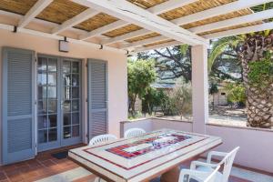 una mesa y sillas en un patio con pérgola en Hotel Delfino, en Procchio