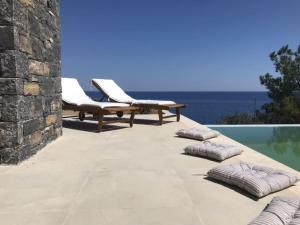 a patio with two lounge chairs and a swimming pool at Villa Avra in Ierápetra
