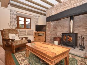 a living room with a wooden table and a fireplace at 1 Bed in Coleford 37217 in Bream