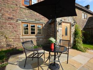 a table with two chairs and an umbrella on a patio at 1 Bed in Coleford 37217 in Bream