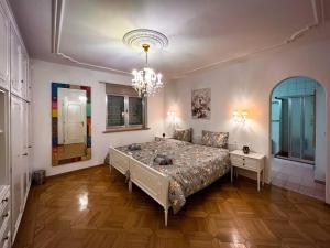 - une chambre avec un grand lit et un lustre dans l'établissement Chalet Maithili Lauterbrunnen -152-Year-Old Majestic Chalet, à Lauterbrunnen