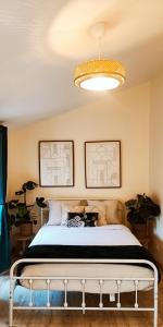 1 dormitorio con cama y lámpara de araña en La Green Room en Poitiers