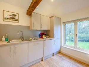a kitchen with white cabinets and a window at 2 Bed in Midhurst 88938 in Midhurst