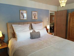 una camera da letto con un grande letto con cuscini bianchi di Chalet M a Davos