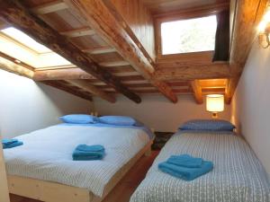 コルティーナ・ダンペッツォにあるCORTINA LODGEのツインベッド2台 木製天井の客室です。
