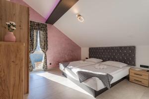 a bedroom with a large bed and a purple wall at Wellness Resort Trebnje in Trebnje +50 photos