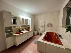 a bathroom with two sinks and a red tub at Chalet Maithili Lauterbrunnen -152-Year-Old Majestic Chalet in Lauterbrunnen +70 photos