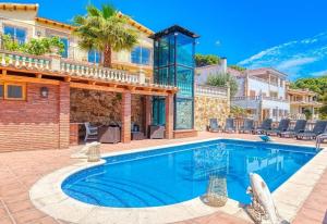 a villa with a swimming pool and a house at Costacabana - Villa Dolce vita in Lloret de Mar