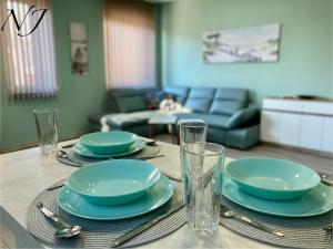 una mesa de comedor con platos y vasos. en NJ Luxury rooms and suites en Varna