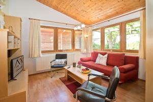 ein Wohnzimmer mit einem roten Sofa und einem Tisch in der Unterkunft Apparthaus & Chalets Hofer in Zell am Ziller