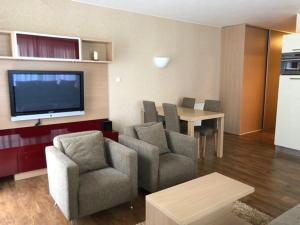 sala de estar con sillas, mesa y TV en Apartman priamo na svahu, en Donovaly