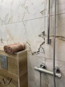 Un baño con ducha y toalla. en NJ Luxury rooms and suites, en Varna