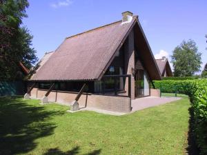 a small house with a roof on a lawn at De Vlier 23 in Nieuwvliet