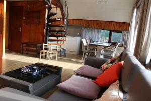 a living room with a couch and a spiral staircase at De Vlier 23 in Nieuwvliet