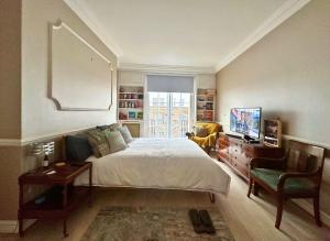a bedroom with a bed and a tv and a chair at Spacious and beautiful flat in Mayfair, Berkeley St in London