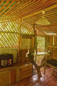 Habitación con techo de madera, mesa y banco. en Arcadea Eco Lodge, 