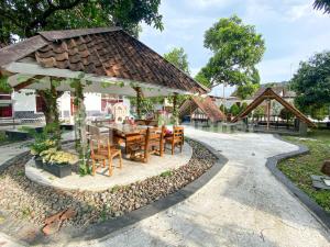 a pavilion with a table and chairs in a park at CBG INN RedPartner near Stasiun Solo Balapan in Kadiporo