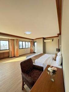 een hotelkamer met een groot bed en een tafel bij United Tower Thonglor by Aspira in Bangkok