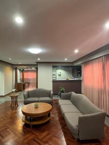 een woonkamer met twee banken en een tafel bij United Tower Thonglor by Aspira in Bangkok