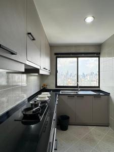 een keuken met uitzicht op de stad vanuit een raam bij United Tower Thonglor by Aspira in Bangkok