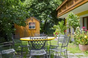 einen Tisch und Stühle in einem Hof mit einem Vogelhaus in der Unterkunft Hotel Rosner in Gablitz
