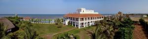 a large building with a tower on top of it at Neemrana's - Bungalow on The Beach in Tarangambādi