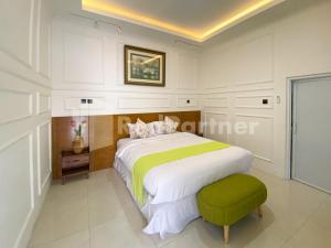 1 dormitorio con 1 cama grande y 1 reposapiés verde en CBG INN RedPartner near Stasiun Solo Balapan en Kadiporo 1