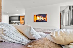 a bedroom with a bed with white pillows and a fireplace at Magnifique appartement rénové in Saas-Fee