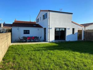 ジャール・シュル・メールにあるLa Maison Manoleの白い家(パティオ、緑の芝生付)