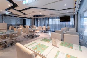 uma sala de conferências com mesas e cadeiras e um ecrã em Guide Hotel Taichung Ziyou em Taichung