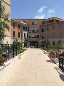 a walkway in front of a large building at New development Place des Lices in Saint-Tropez