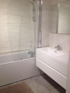 ein weißes Bad mit einem Waschbecken und einer Dusche in der Unterkunft New development Place des Lices in Saint-Tropez