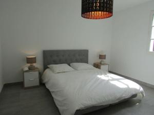 ein Schlafzimmer mit einem weißen Bett und zwei Nachttischen in der Unterkunft New development Place des Lices in Saint-Tropez